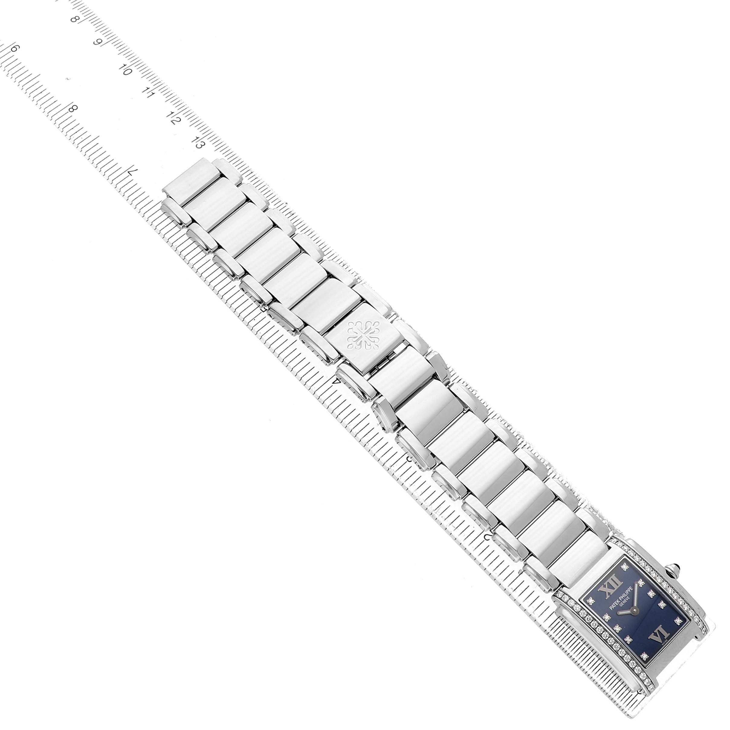 The image shows a top-down view of a Patek Philippe Twenty-4 4910/10A Women's Stainless Steel Blue Dial watch, featuring its bracelet and a portion of the blue dial.