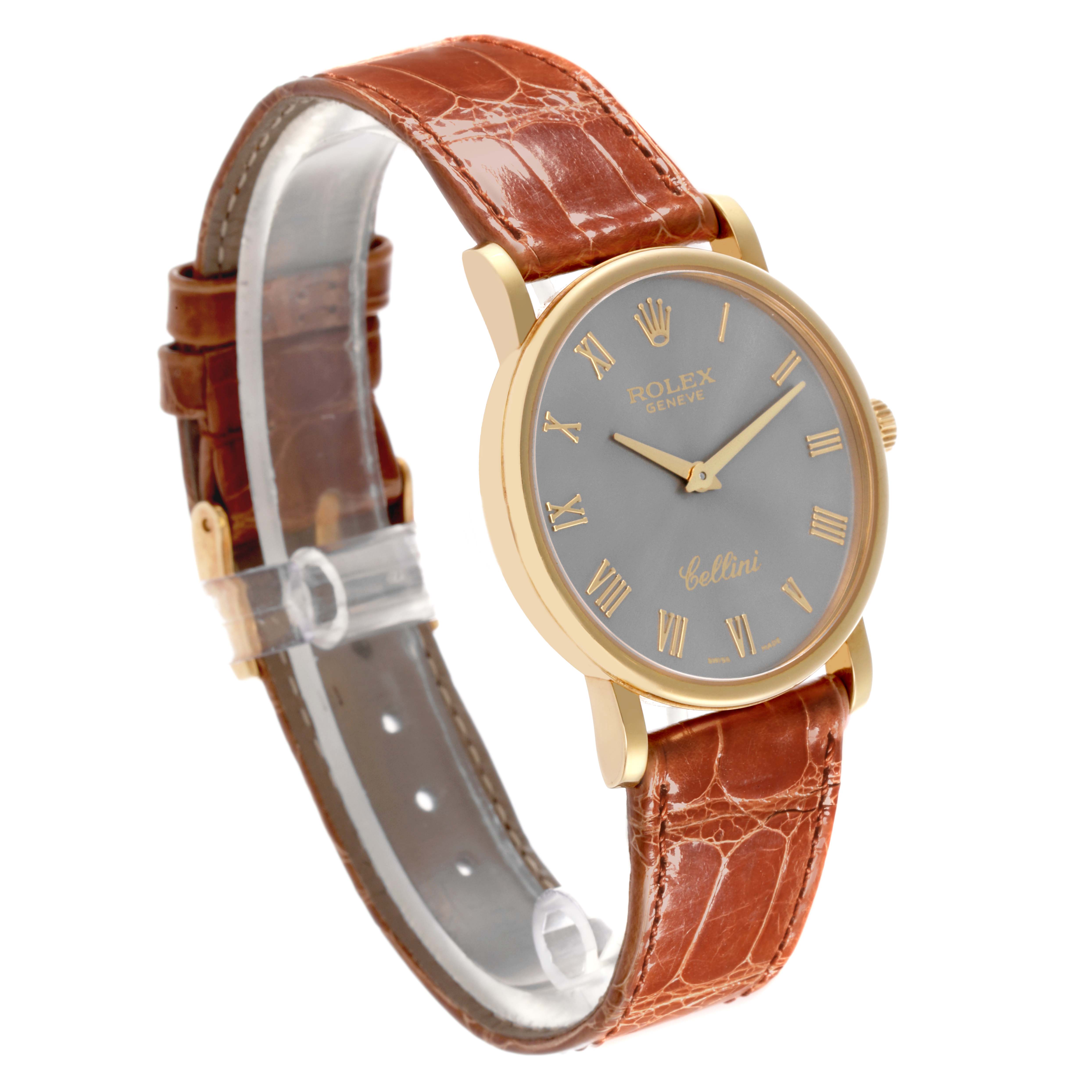 The Rolex Cellini 5115 Men's Yellow Gold Grey Dial 5115 Men's Yellow Gold Grey Dial watch is shown at a three-quarter angle, highlighting the gold case, brown leather strap, and grey dial with gold Roman numerals.
