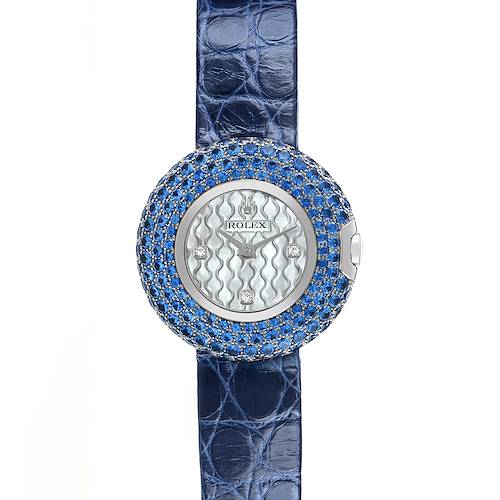 The Rolex Cellini 6201 Women's White Gold Mother of Pearl Dial watch is shown from a front angle, highlighting its blue gemstone-encrusted bezel and textured dial with a blue leather strap.