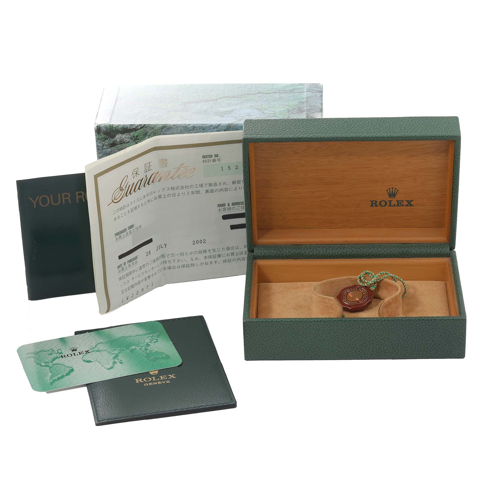 The image shows a green Rolex box for the Date model, open with a certification, a card, and a booklet.