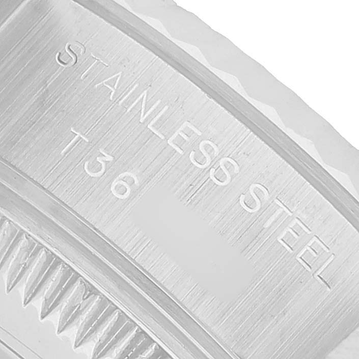 The image shows a close-up of the stainless steel bezel edge with engravings on a Rolex Datejust 69174 Women's Stainless Steel White Dial watch.