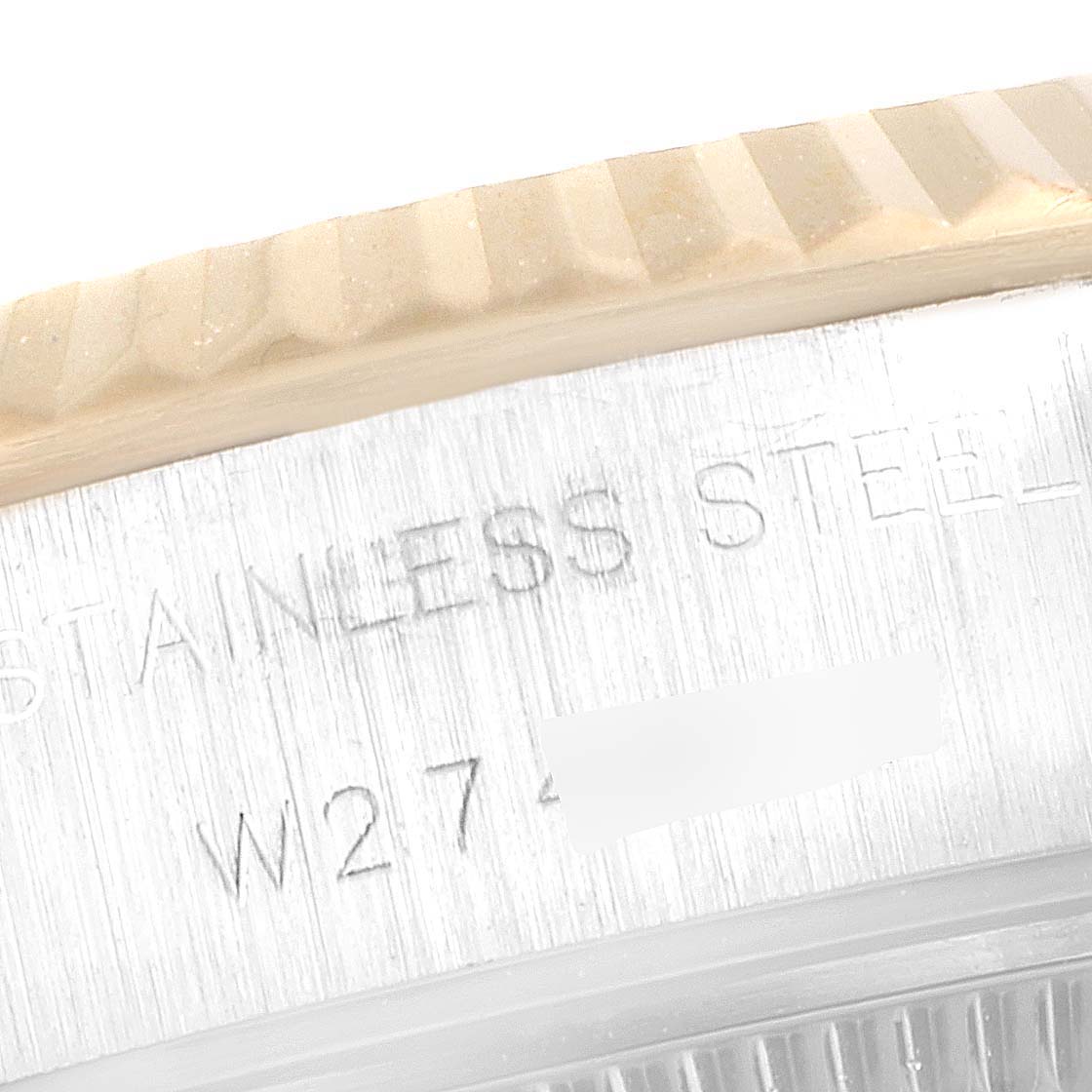 This image shows a close-up of the side of the case and part of the bezel of a Rolex Datejust 69173 Women's Steel and Gold (two tone) Champagne Dial 69173 Women's Steel and Gold (two tone) Champagne Dial watch, displaying "Stainless Steel."