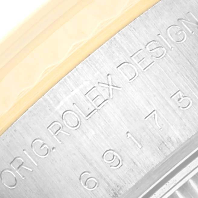 The image shows a close-up of the engraved side of a Rolex Datejust 69173 Women's Steel and Gold (two tone) Champagne Dial 69173 Women's Steel and Gold (two tone) Champagne Dial watch case.