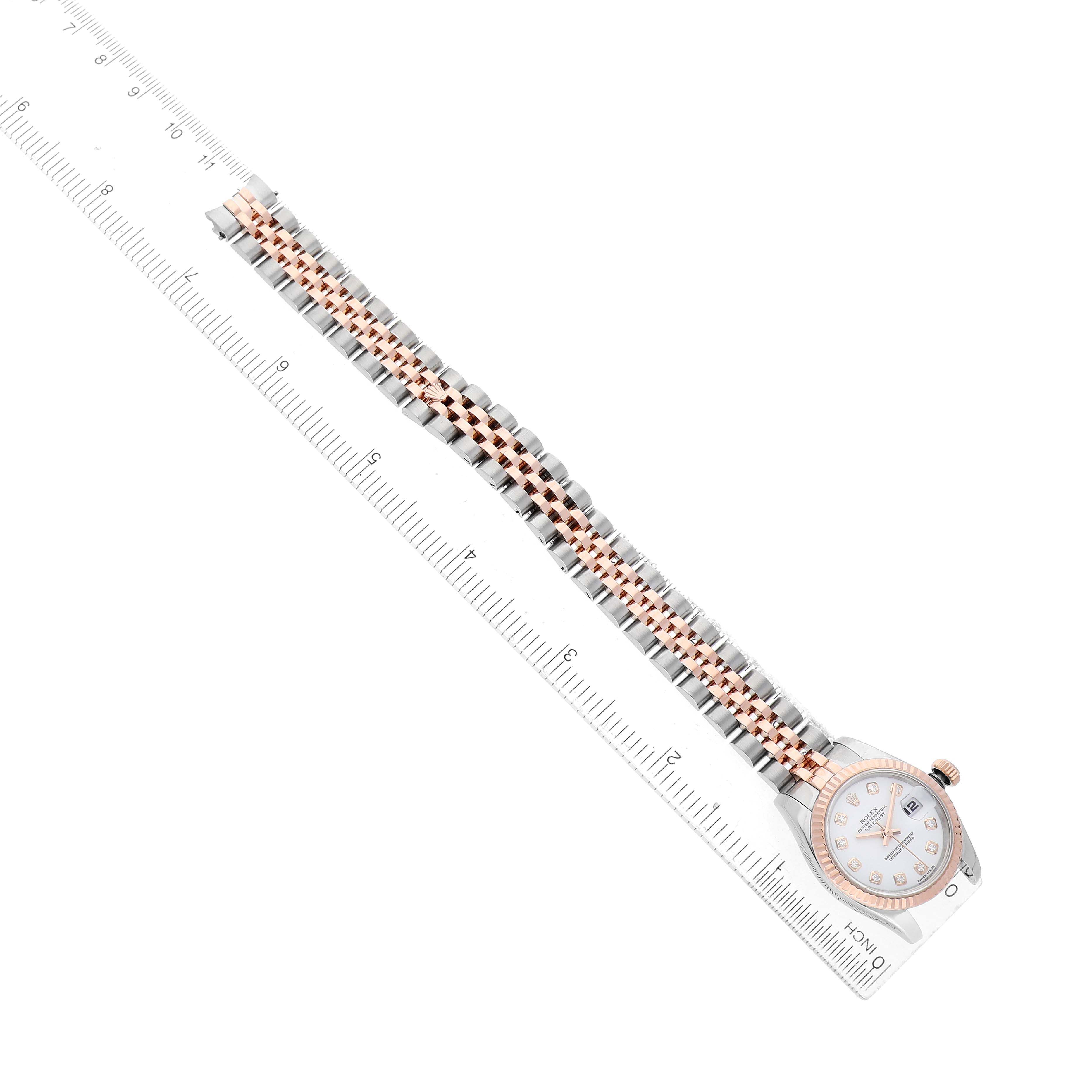 The Rolex Datejust 179171 Women's Steel and Gold (two tone) White Dial watch is displayed diagonally, showing the full bracelet and the dial next to a ruler for scale.