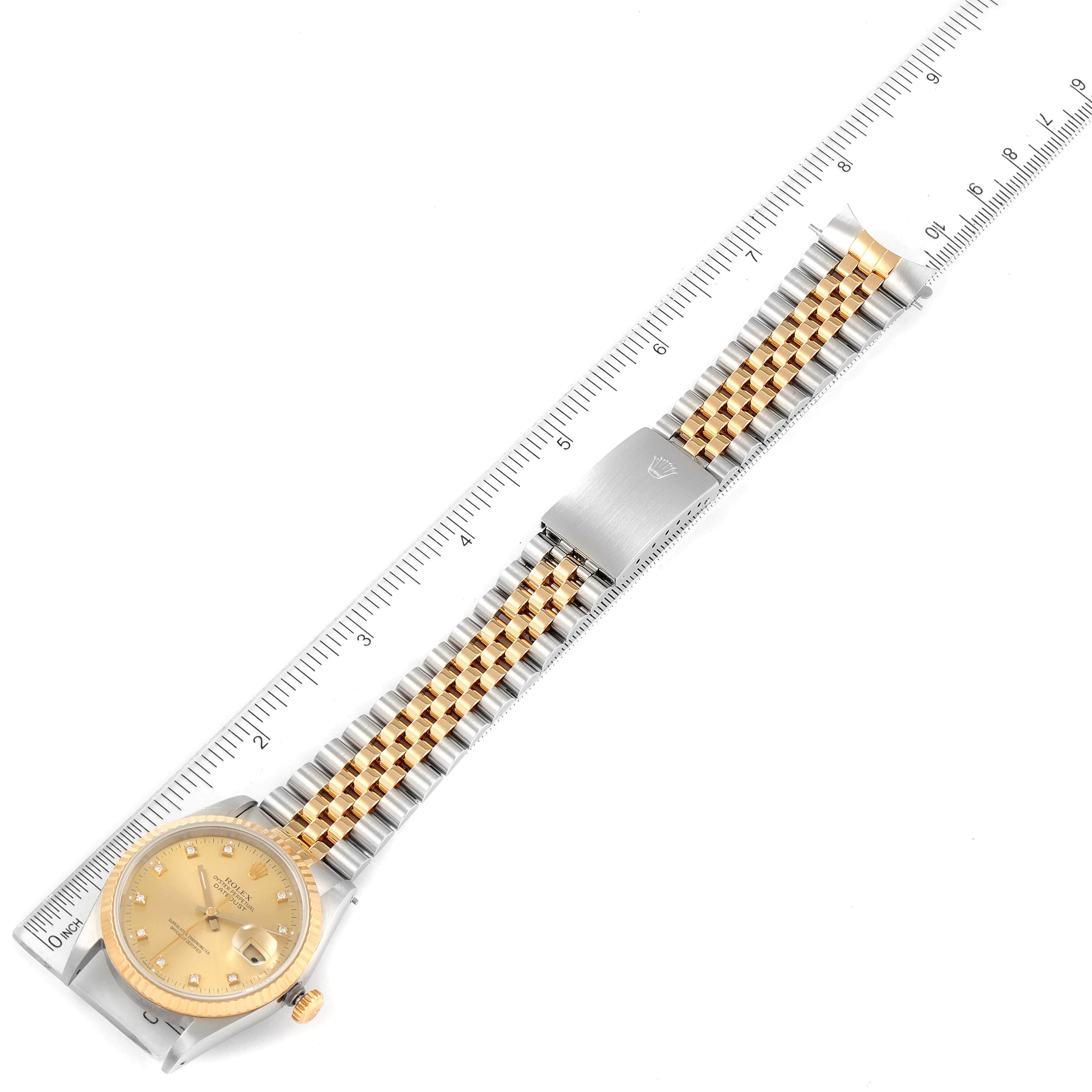 The Rolex Datejust 16233 Men's Steel and Gold (two tone) Champagne Dial 16233 Men's Steel and Gold (two tone) Champagne Dial watch is shown from a top-down angle, displaying the entire face and band alongside a measuring ruler.