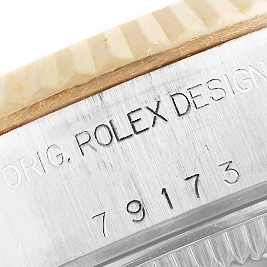 This image shows a close-up of the bezel and case side of a Rolex Datejust 79173 Women's Steel and Gold (two tone) Beige Dial 79173 Women's Steel and Gold (two tone) Beige Dial watch, featuring the engraving.