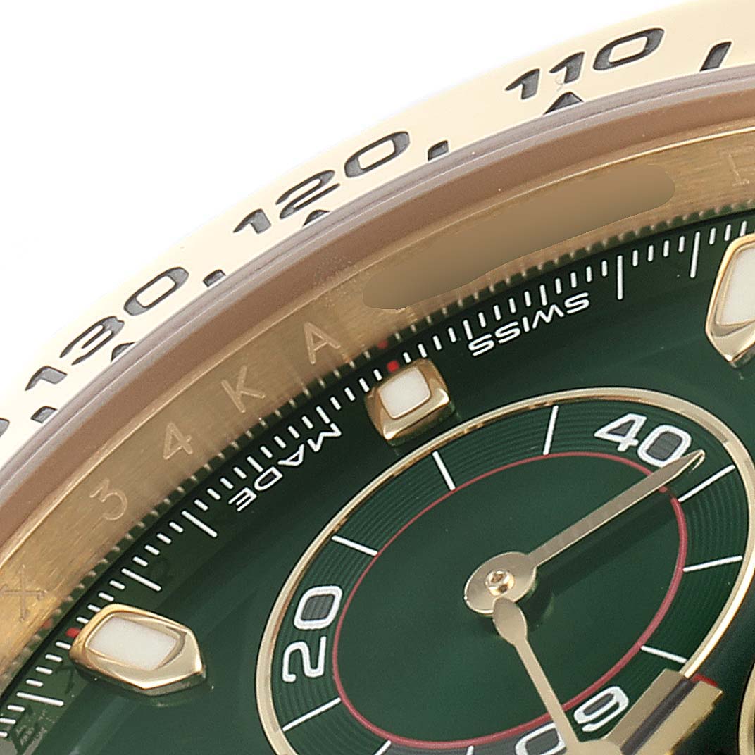 This close-up photo of the Rolex Daytona 116508 Men's Yellow Gold Green Dial 116508 Men's Yellow Gold Green Dial watch shows part of its dial and bezel, highlighting the green face and tachymeter scale.