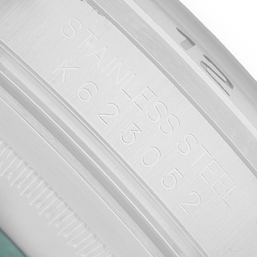 The image shows a close-up of the engraving on the side of a Rolex Explorer 16570 Men's Stainless Steel White Dial watch case, highlighting the serial number.