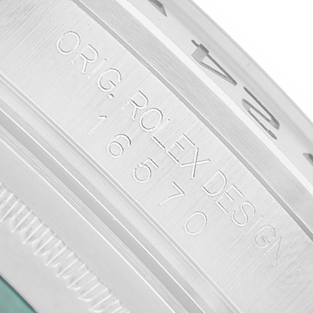 The image shows a close-up of the engraved bezel and side of a Rolex Explorer 16570 Men's Stainless Steel White Dial watch, highlighting the model number.