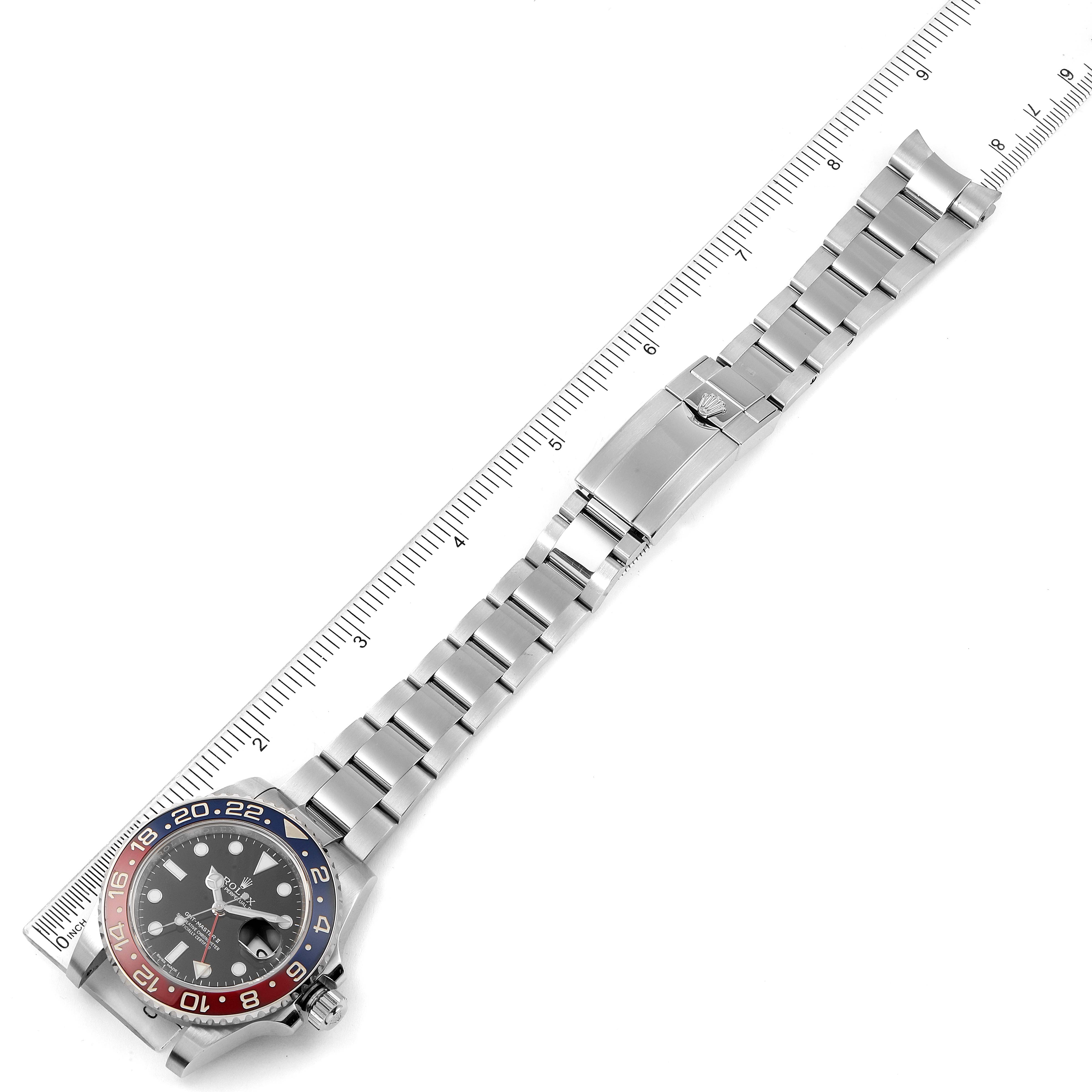 The Rolex GMT-Master 116719 Men's White Gold Black Dial 116719 Men's White Gold Black Dial watch is shown from a top view, including its face, bezel, and full bracelet with a ruler.