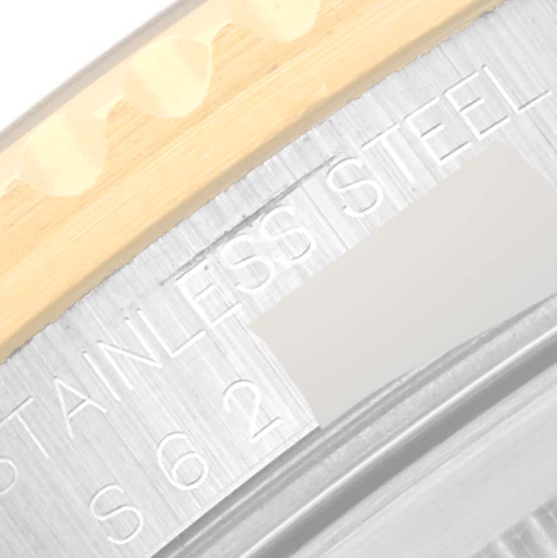 This close-up image shows part of the bezel and case back of a Rolex GMT-Master 16713 Men's Steel and Gold (two tone) Black Dial 16713 Men's Steel and Gold (two tone) Black Dial, highlighting the "STAINLESS STEEL" engraving.