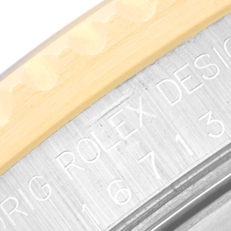This close-up image shows the inscription on the side of a Rolex GMT-Master 16713 Men's Steel and Gold (two tone) Black Dial 16713 Men's Steel and Gold (two tone) Black Dial watch, including part of the bezel and case.