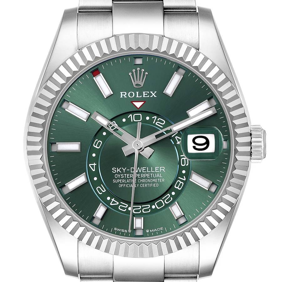 The image shows a Rolex Sky-Dweller watch from a front angle, highlighting its green dial, hands, date window, and fluted bezel.