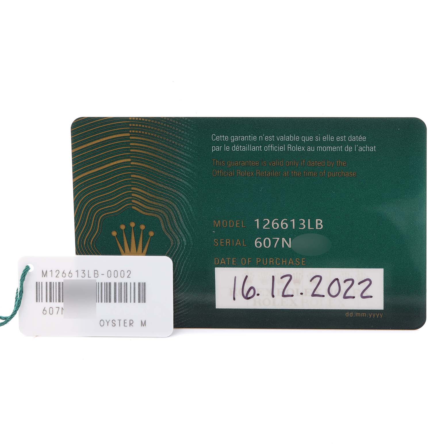 The image shows a Rolex Submariner 126613LB Men's Steel and Gold (two tone) Blue Dial 126613LB Men's Steel and Gold (two tone) Blue Dial model 126613LB warranty card and a tag with reference numbers and purchase date.