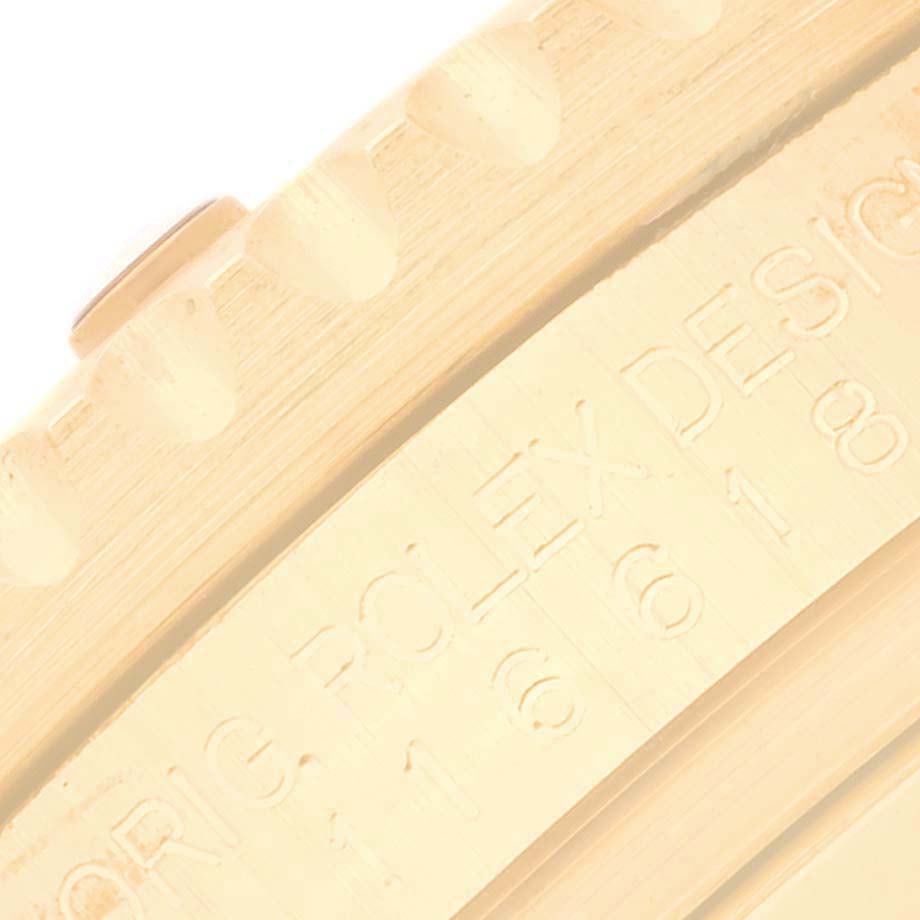The image shows a close-up of the engraved side of the bezel of a Rolex Submariner 116618 Men's Yellow Gold Black Dial 116618 Men's Yellow Gold Black Dial watch.