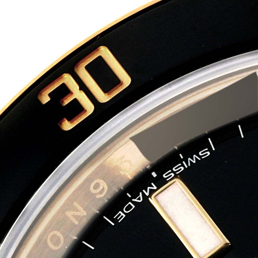 This close-up image shows a partial view of the bezel, dial, and Swiss Made text of the Rolex Submariner 116618 Men's Yellow Gold Black Dial 116618 Men's Yellow Gold Black Dial watch.
