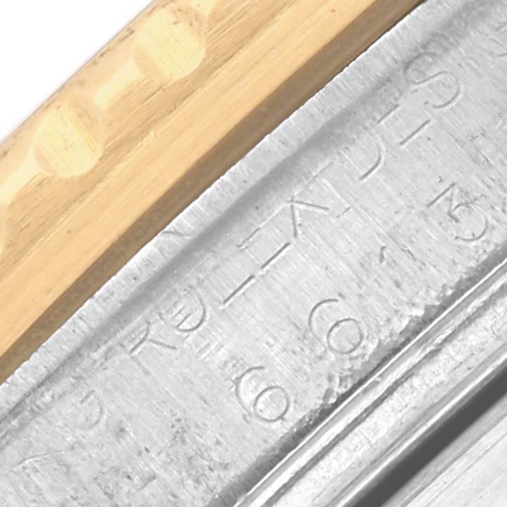 The image shows a close-up of the bezel's edge and engraved text on the casing of a Rolex Submariner 16613 Men's Steel and Gold (two tone) Blue Dial 16613 Men's Steel and Gold (two tone) Blue Dial watch.