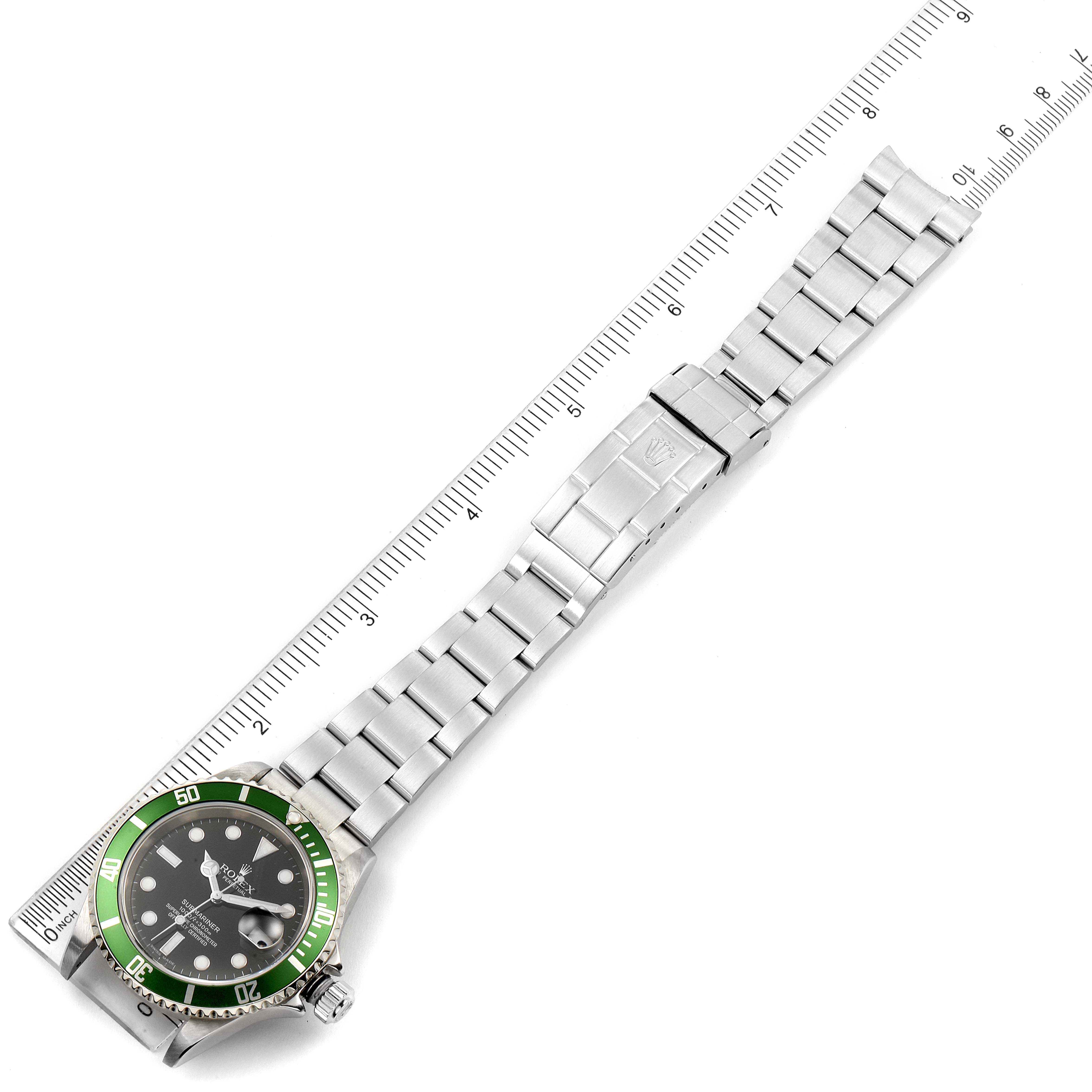 The Rolex Submariner 16610LV Men
s Stainless Steel Black Dial 16610LV Men
s Stainless Steel Black Dial watch is shown from an overhead angle, highlighting its green bezel, dial, and stainless steel bracelet on a ruler.