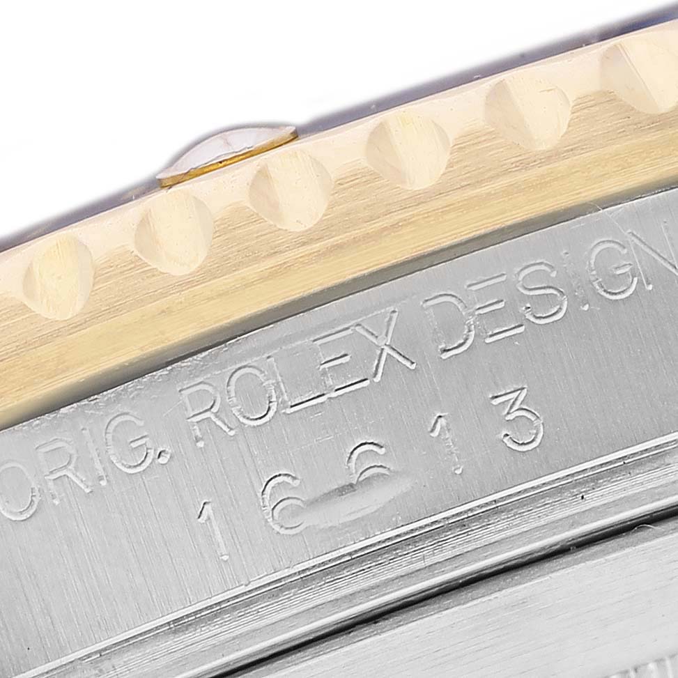 The image shows a close-up of the side of a Rolex Submariner 16613 Men's Steel and Gold (two tone) Champagne Dial bezel and case with engraved model details.