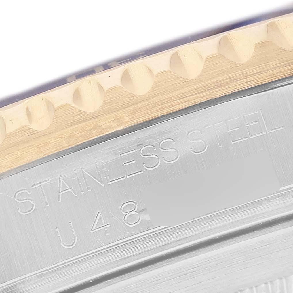 The image shows a close-up of the Rolex Submariner 16613 Men's Steel and Gold (two tone) Champagne Dial's case, highlighting the engraving and bezel edge.