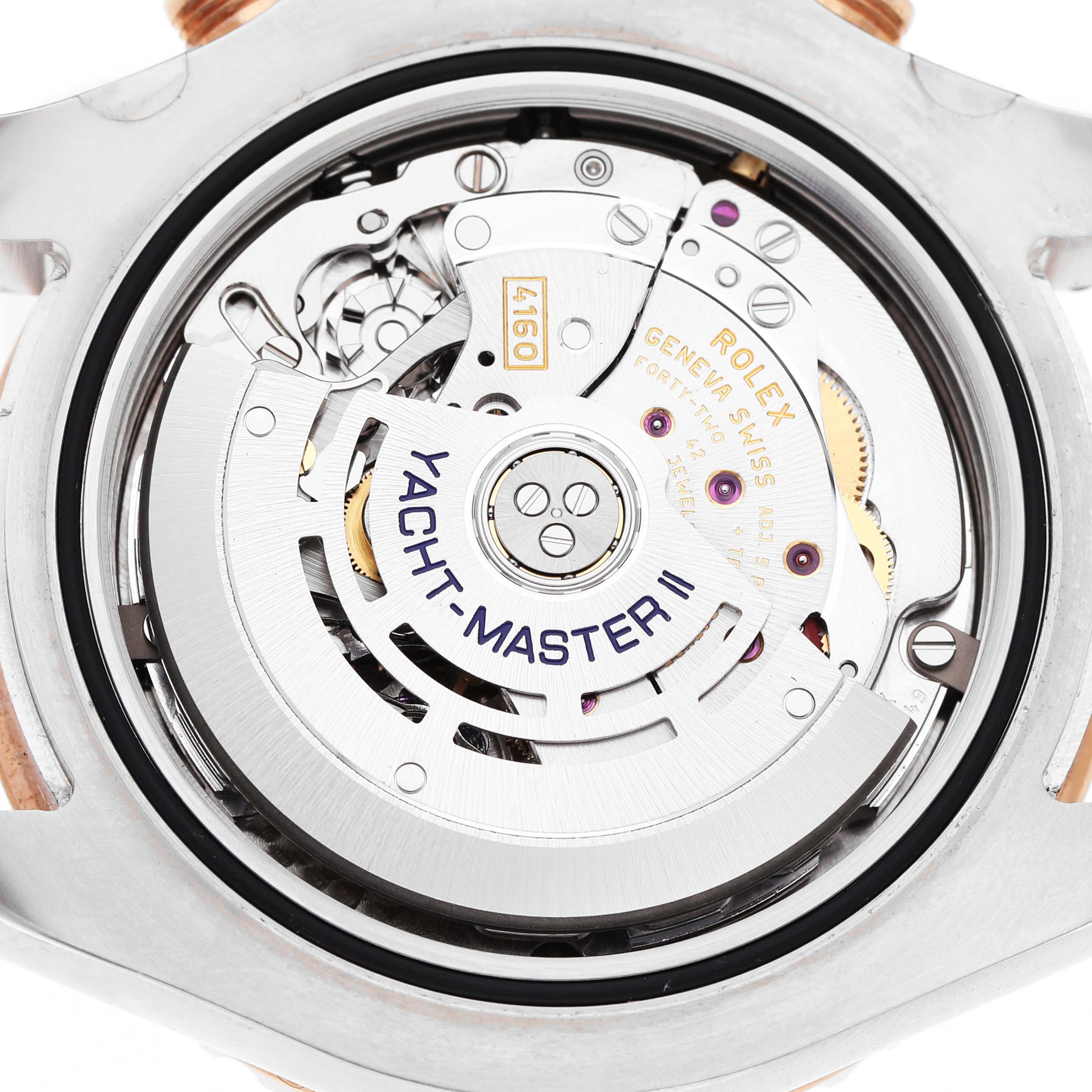 The image shows the Rolex Yacht-Master 116681M Men's Steel and Gold (two tone) White Dial II watch movement from a rear angle, highlighting its intricate mechanical details.
