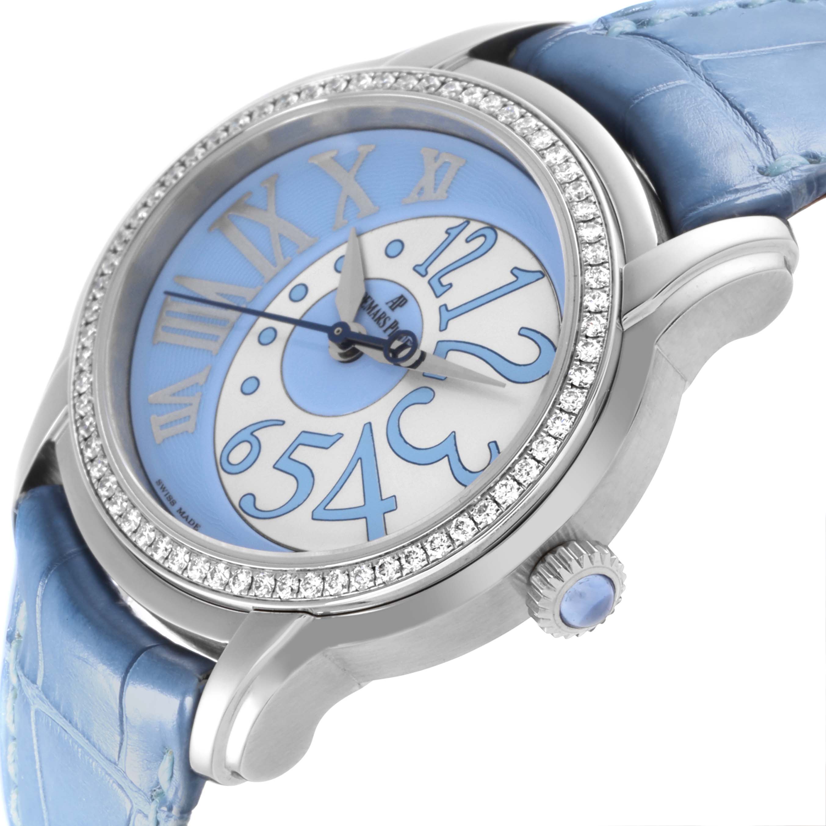 The Audemars Piguet Millenary 77301ST.ZZ.D303CR.01 Women's White Gold Blue Dial 77301ST.ZZ.D303CR.01 Women's White Gold Blue Dial watch is shown at a side angle, highlighting the dial, diamond bezel, crown, and blue leather strap.