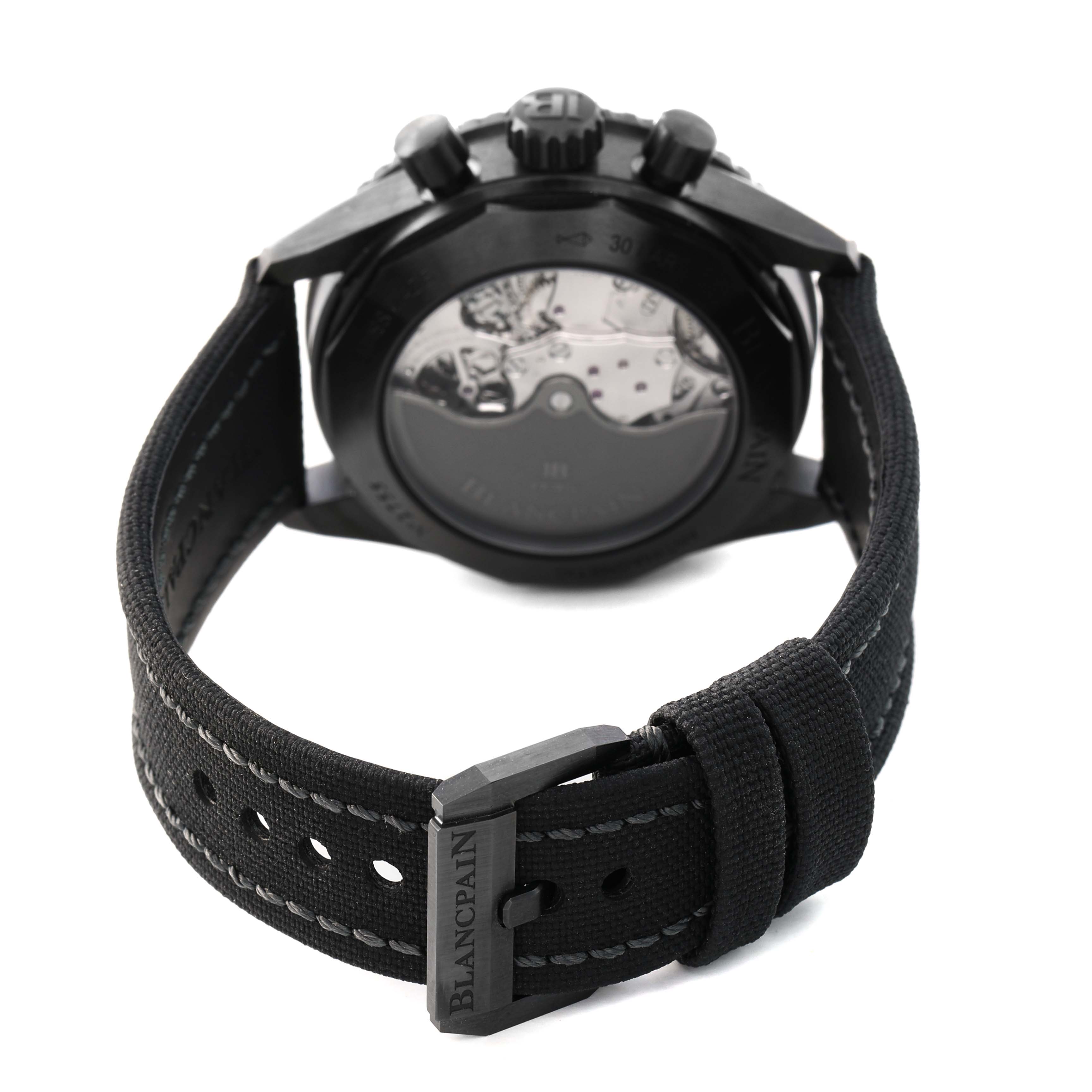 The Blancpain Fifty Fathoms 5200-0130-B52A Men's Ceramic Black Dial watch is shown from the back, highlighting the movement and canvas strap with a signed buckle.