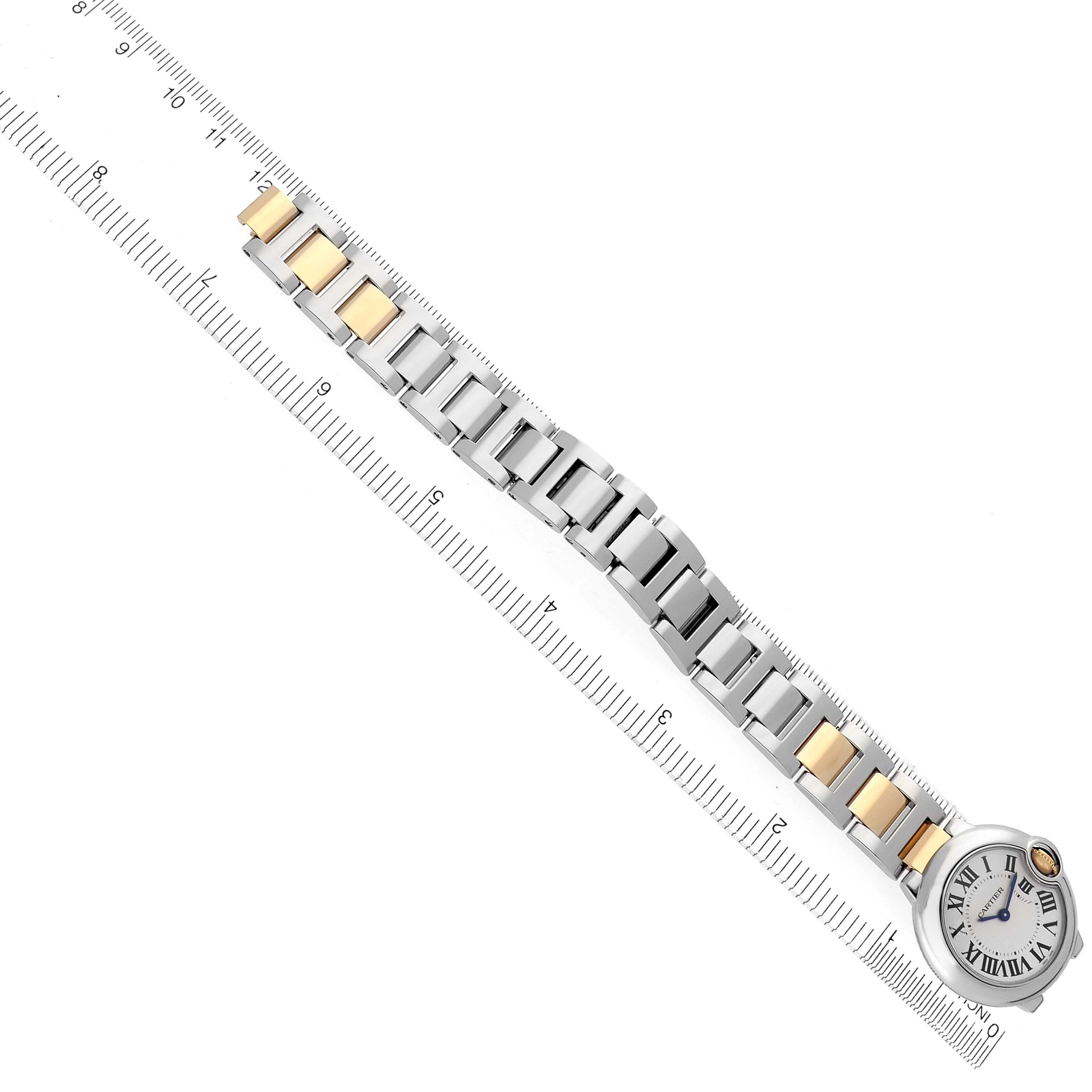 The Cartier Ballon Bleu W2BB0010 Women's Steel and Gold (two tone) Silver Dial W2BB0010 Women's Steel and Gold (two tone) Silver Dial watch is shown diagonally with a full view of the two-tone bracelet and face alongside a ruler.