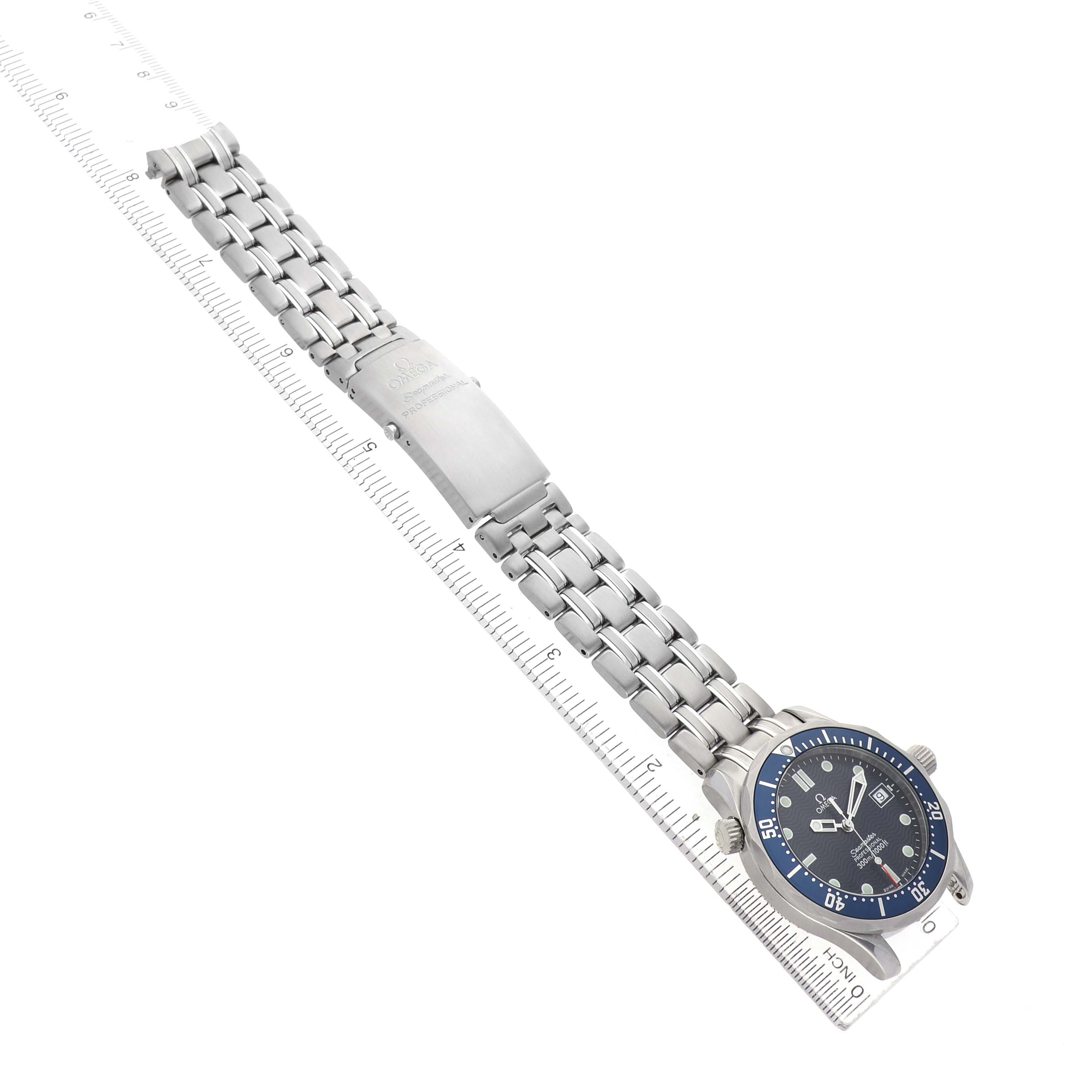 The Omega Seamaster 2561.80.00 Men's Stainless Steel Blue Dial watch is shown from a top-down angle, displaying the face, bezel, bracelet, and clasp alongside a ruler.