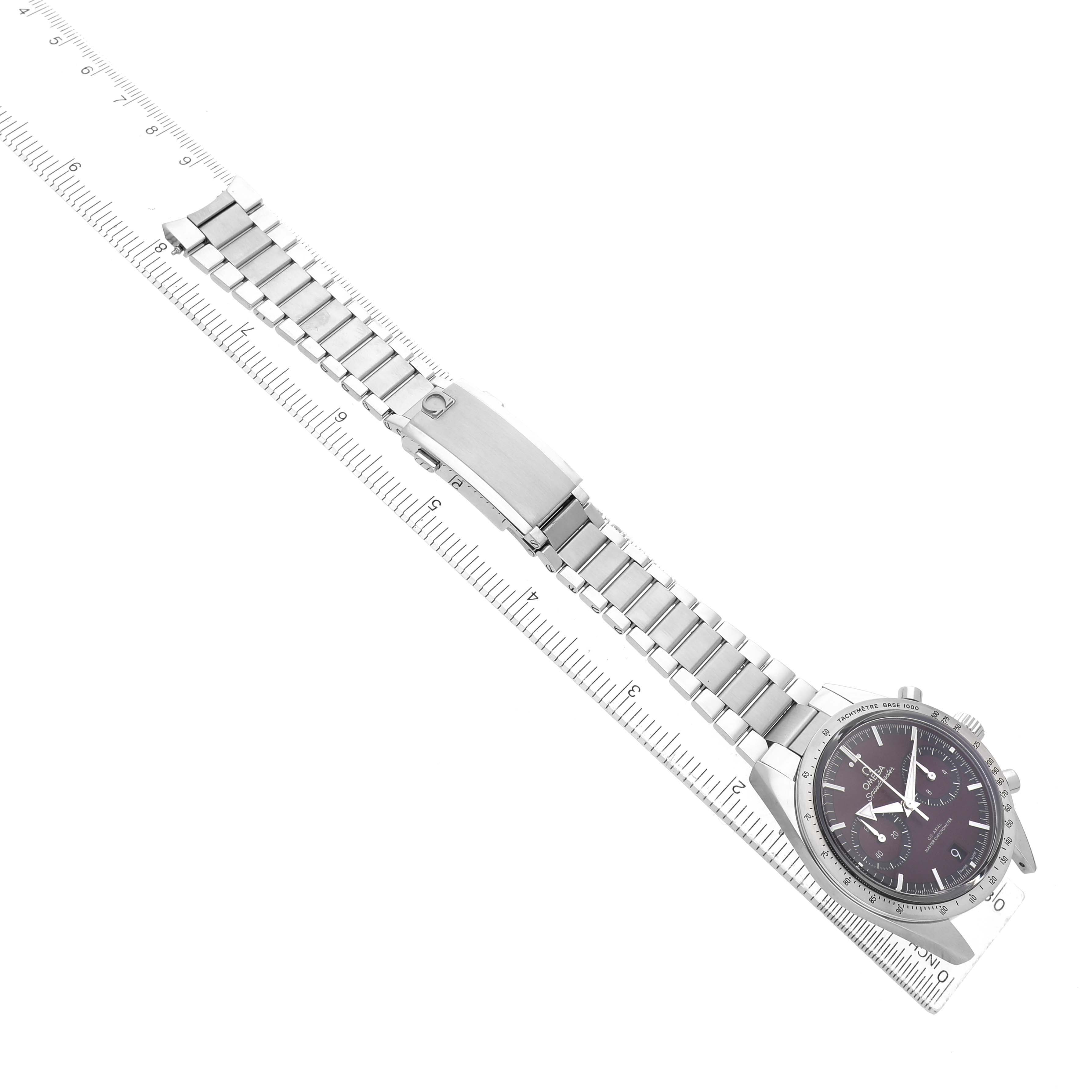 The Omega Speedmaster 332.10.41.51.11.001 Men's Stainless Steel Red Dial watch is displayed from an overhead angle, showing the full case and metal bracelet alongside a ruler.
