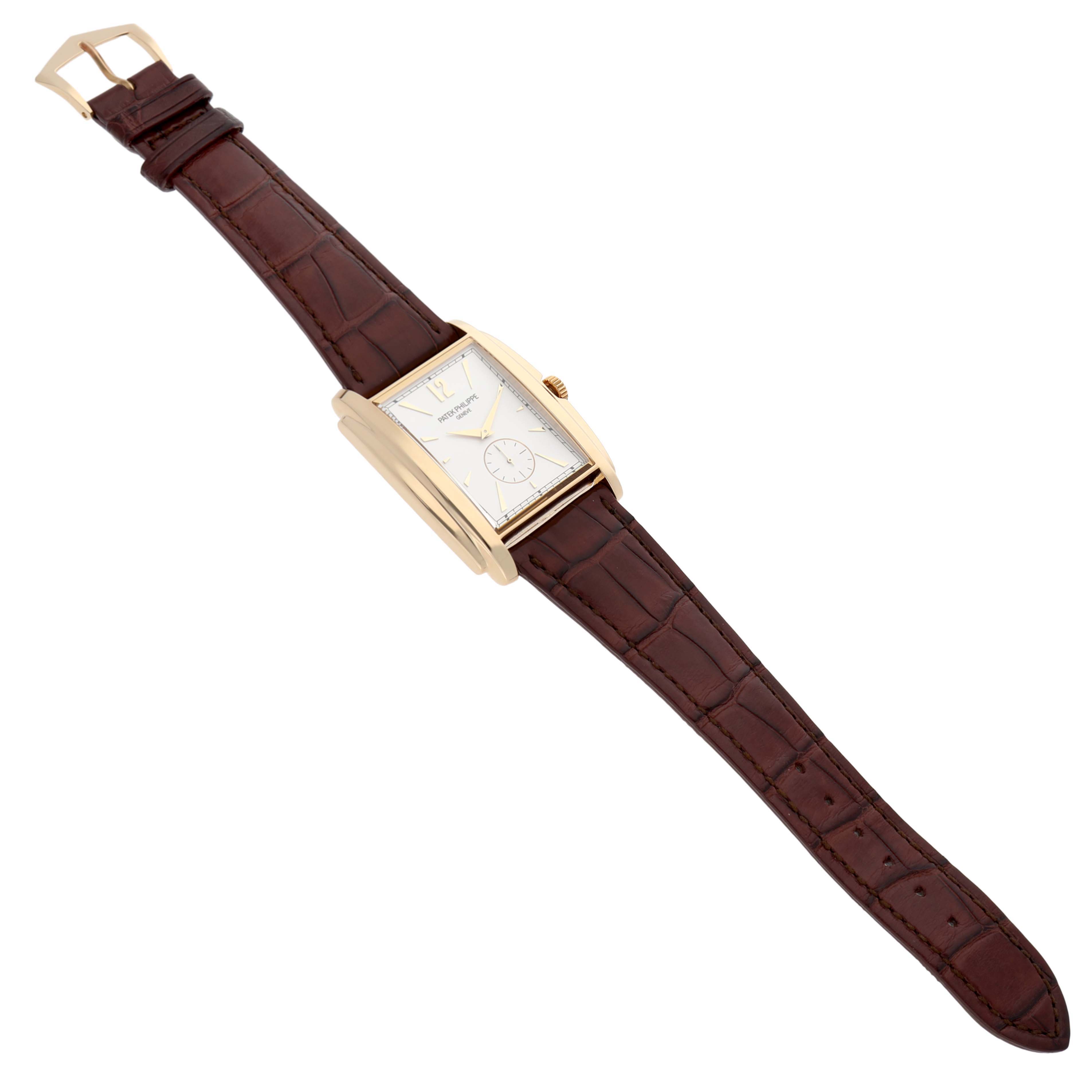 The Patek Philippe Gondolo 5124J-001 Men's Yellow Gold Silver Dial watch is shown at a slight angle, displaying its case, face, and brown strap.