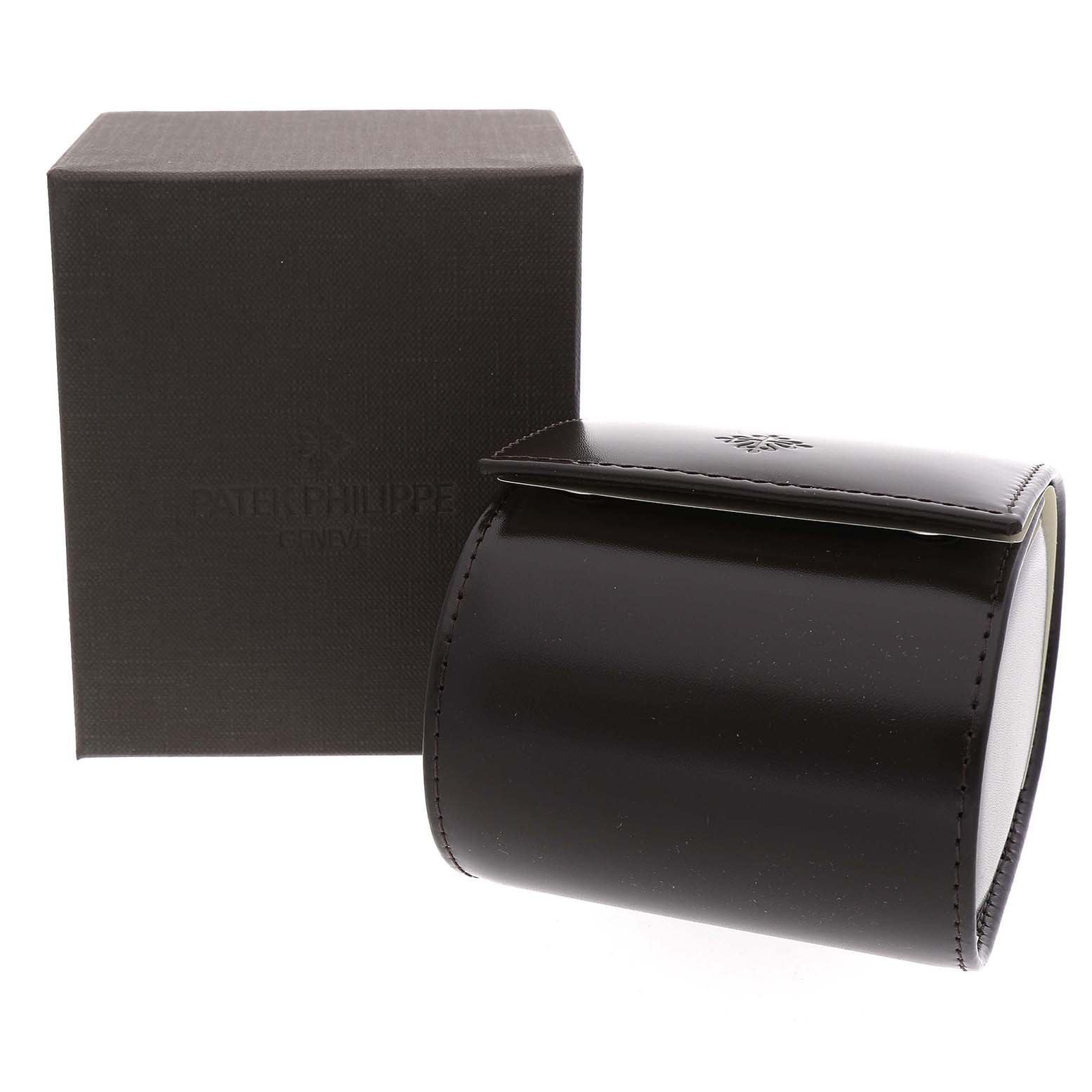 The image shows a Patek Philippe Gondolo 5124J-001 Men's Yellow Gold Silver Dial watch box and a dark, glossy leather watch case, positioned at an angled view.