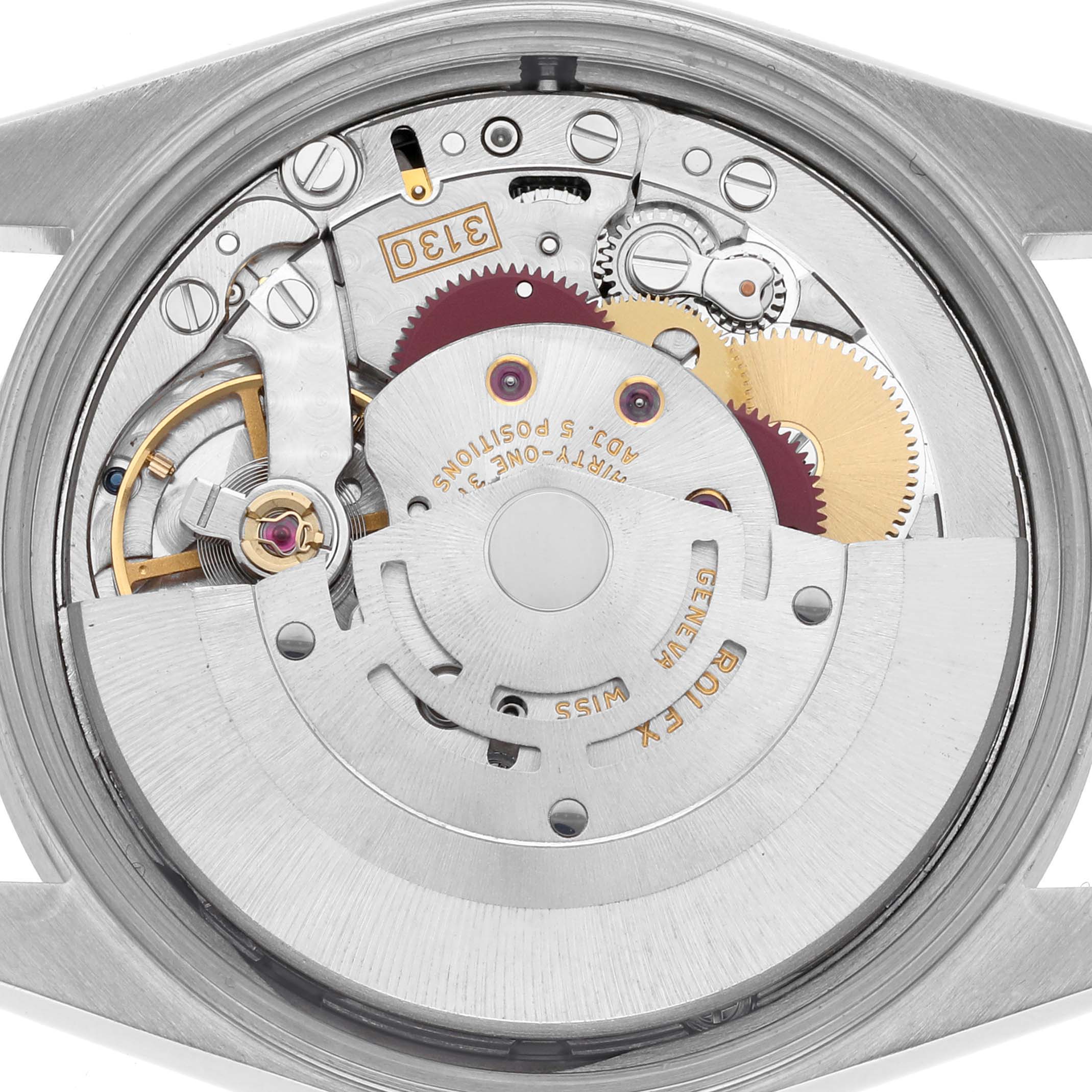 The image shows the movement mechanism of a Rolex Datejust watch from a back angle, revealing gears and components.