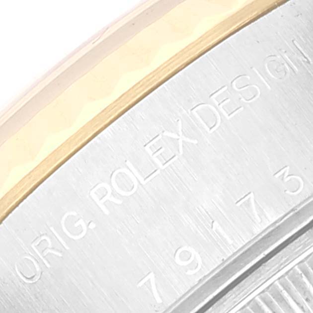 The image shows a close-up of the bezel and part of the casing of a Rolex Datejust 79173 Women's Steel and Gold (two tone) White Dial 79173 Women's Steel and Gold (two tone) White Dial watch with "ORIG. ROLEX DESIGN" engraved.