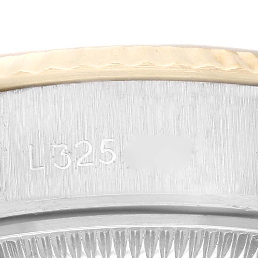 This image shows a close-up of the serial number and part of the bezel and case edge of a Rolex Datejust 69173 Women's Steel and Gold (two tone) Silver Dial 69173 Women's Steel and Gold (two tone) Silver Dial watch.