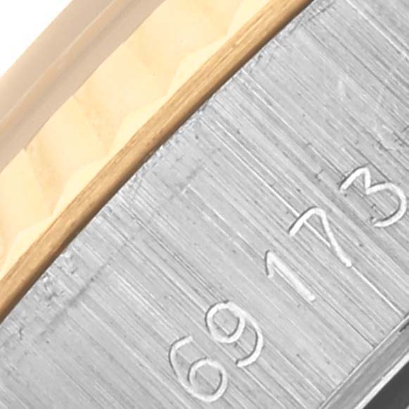 The image shows a close-up of the side of the bezel and part of the case with a serial number on a Rolex Datejust 69173 Women's Steel and Gold (two tone) Black Dial 69173 Women's Steel and Gold (two tone) Black Dial watch.