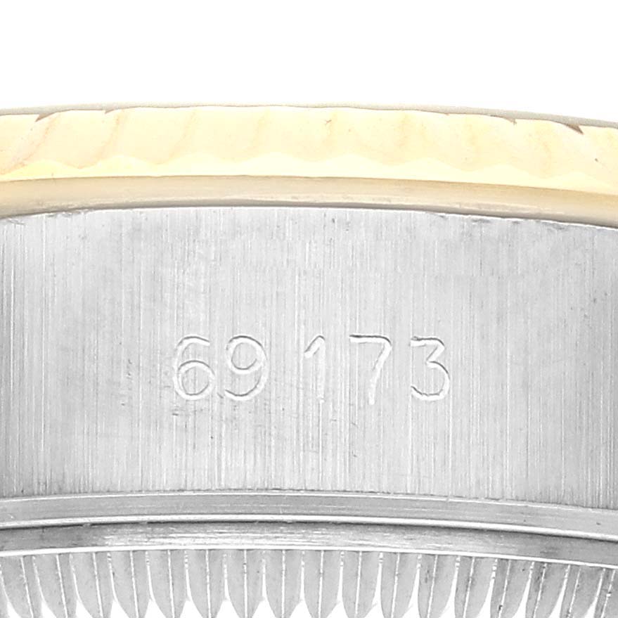 The image shows a close-up of the side of a Rolex Datejust 69173 Women's Steel and Gold (two tone) Champagne Dial 69173 Women's Steel and Gold (two tone) Champagne Dial watch case with engraved model numbers.