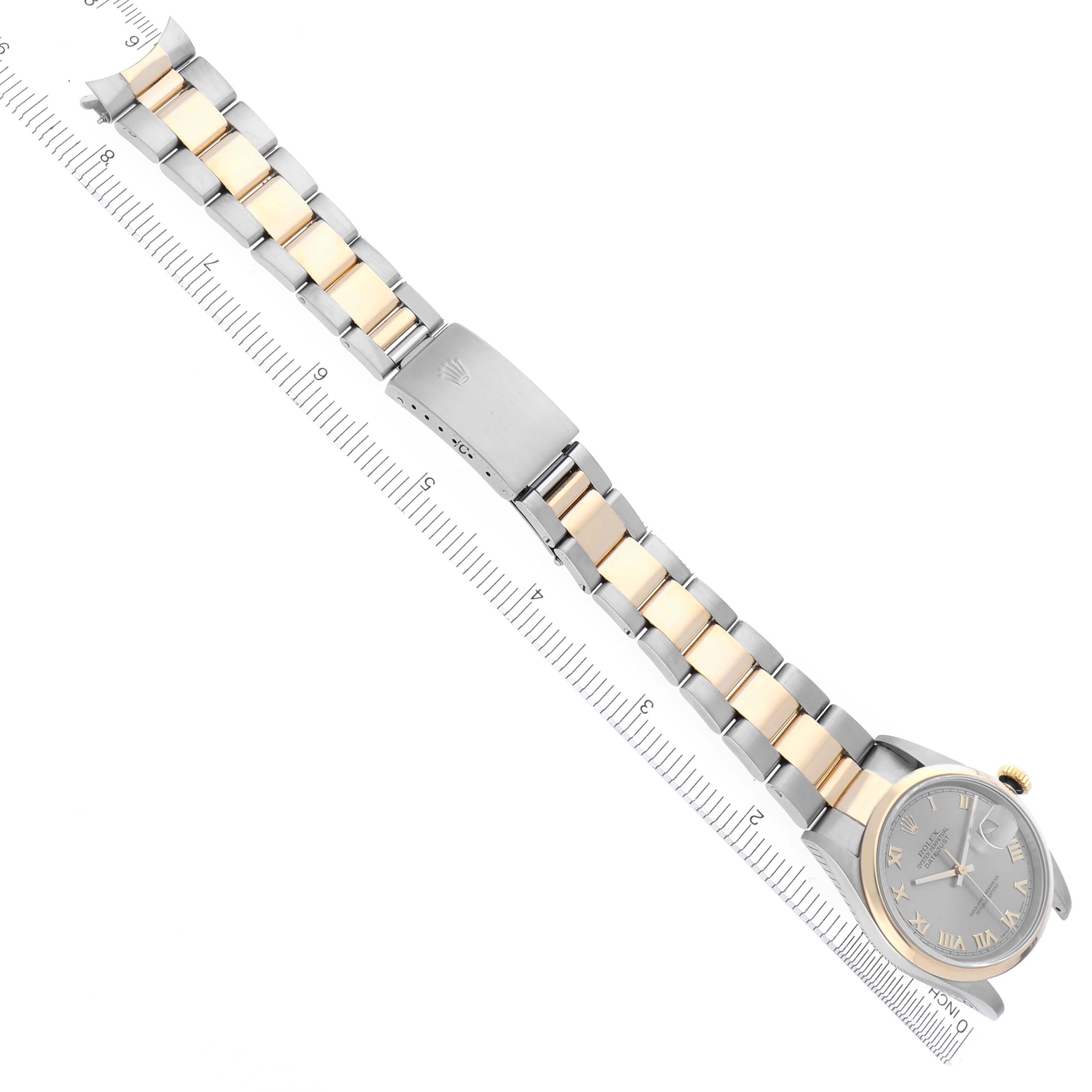 The Rolex Datejust 16203 Men's Steel and Gold (two tone) Grey Dial 16203 Men's Steel and Gold (two tone) Grey Dial watch is shown at an angled top view, highlighting the bracelet and watch face alongside a measuring scale.