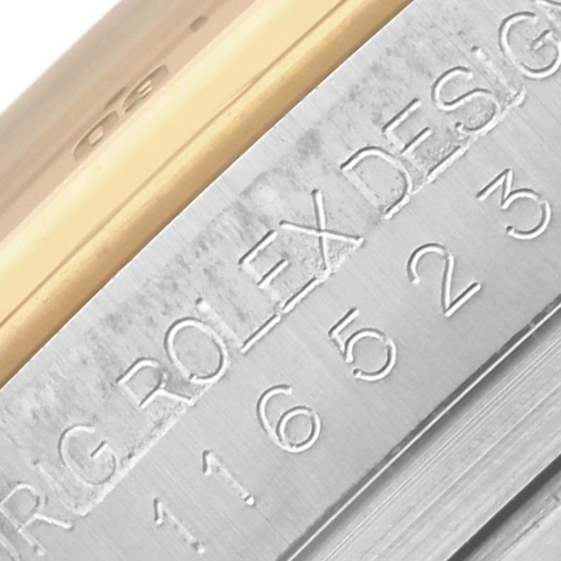 The image shows a close-up of the edge and engraving on the case of a Rolex Daytona 116523 Men's Steel and Gold (two tone) Grey Dial 116523 Men's Steel and Gold (two tone) Grey Dial watch.