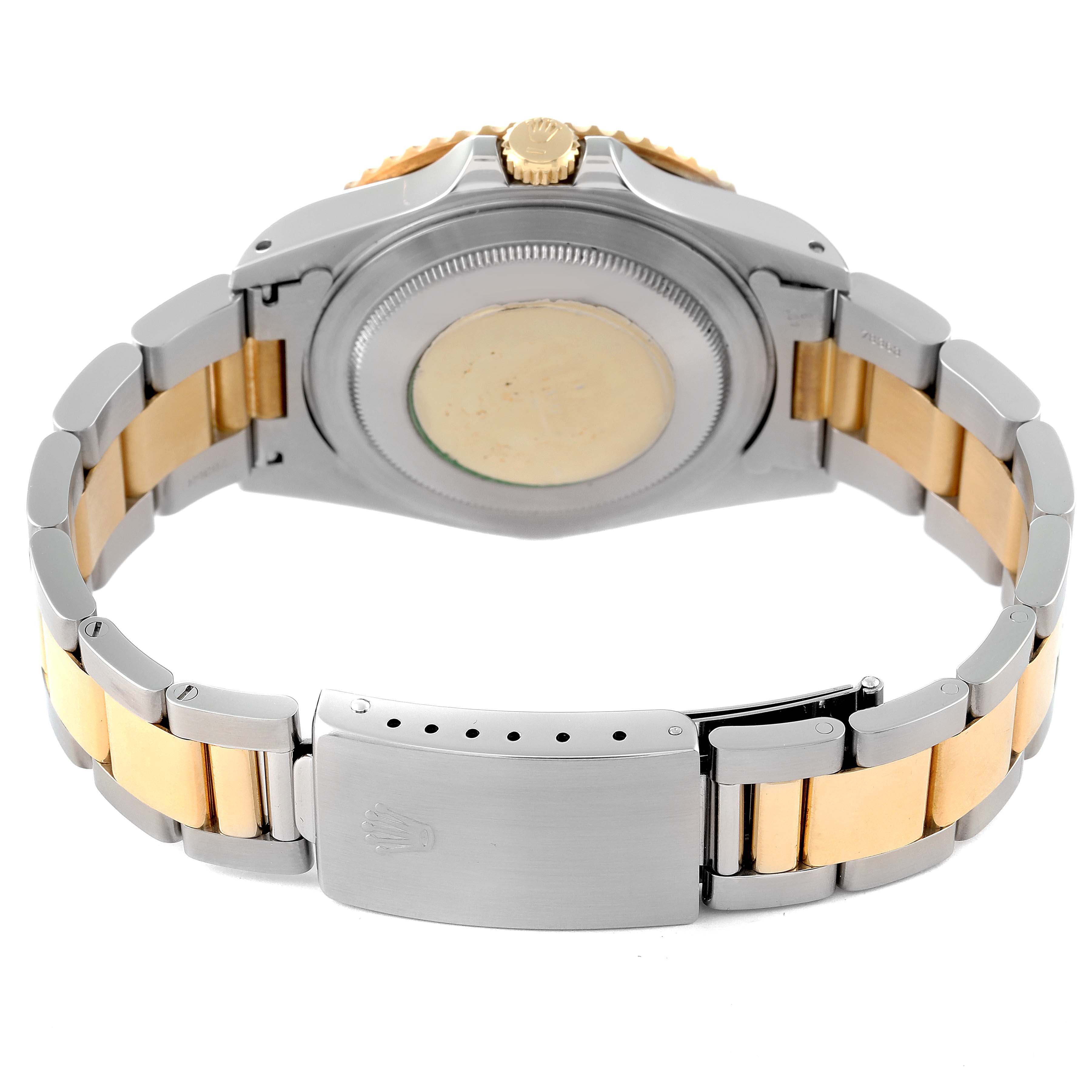The image shows the backside and bracelet of a Rolex GMT-Master 16713 Men's Steel and Gold (two tone) Champagne Dial 16713 Men's Steel and Gold (two tone) Champagne Dial watch, highlighting its case and clasp.