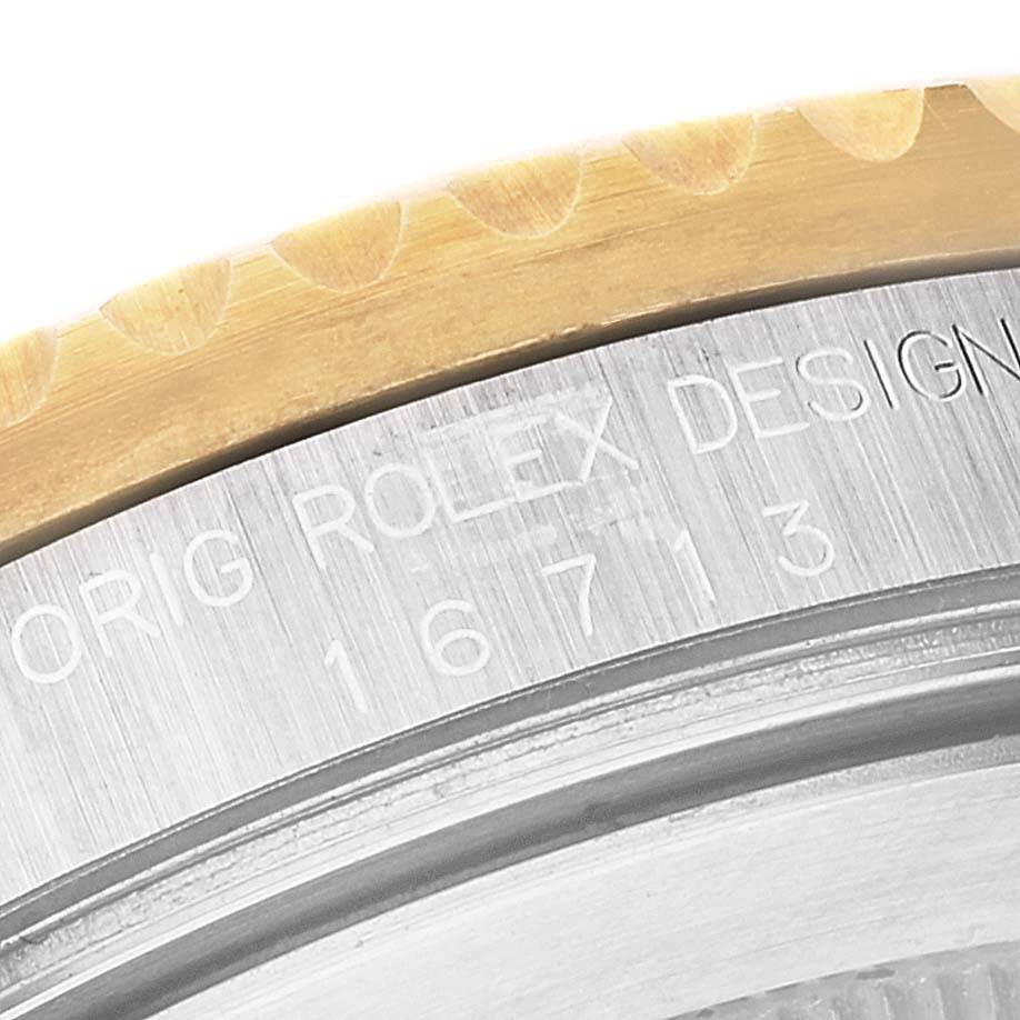 The image shows a close-up of the engraved bezel and case part of the Rolex GMT-Master 16713 Men's Steel and Gold (two tone) Champagne Dial 16713 Men's Steel and Gold (two tone) Champagne Dial model.