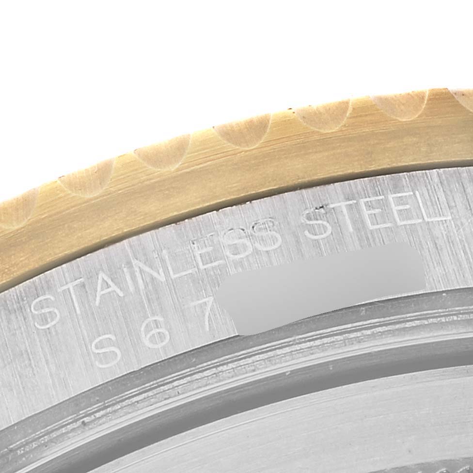 This image shows a close-up of the stainless steel case back and bezel edge of a Rolex GMT-Master 16713 Men's Steel and Gold (two tone) Champagne Dial 16713 Men's Steel and Gold (two tone) Champagne Dial watch.