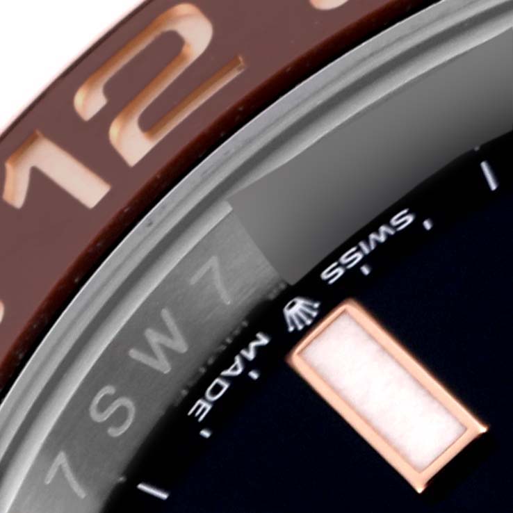 The image shows a close-up of the Rolex GMT-Master 126711CHNR Men's Steel and Gold (two tone) Black Dial 126711CHNR Men's Steel and Gold (two tone) Black Dial bezel, dial edge, and part of a numeral.