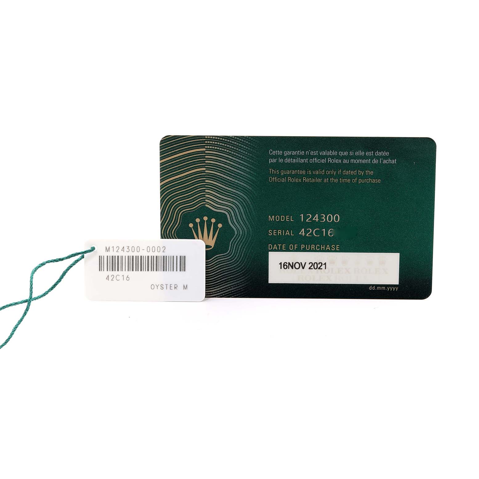 The image shows a Rolex Oyster Perpetual 124300 Men
s Stainless Steel Black Dial 124300 Men
s Stainless Steel Black Dial model warranty card and a tag with the model and serial number details.