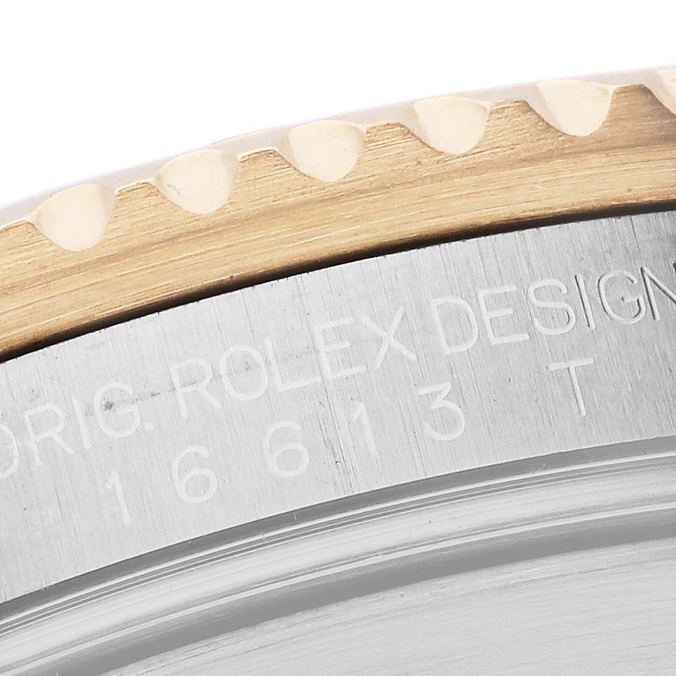 The image shows a close-up of the bezel and engraved edge of a Rolex Submariner 16613LB Men's Steel and Gold (two tone) Blue Dial 16613LB Men's Steel and Gold (two tone) Blue Dial watch.