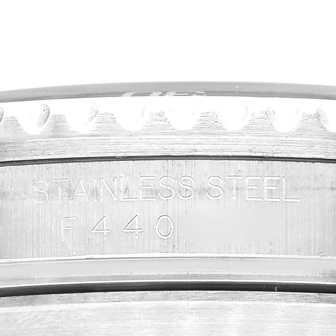 The image shows a close-up of the bezel and case back edge of a Rolex Submariner 16610LV Men's Stainless Steel Black Dial 16610LV Men's Stainless Steel Black Dial watch, highlighting its "STAINLESS STEEL" engraving.