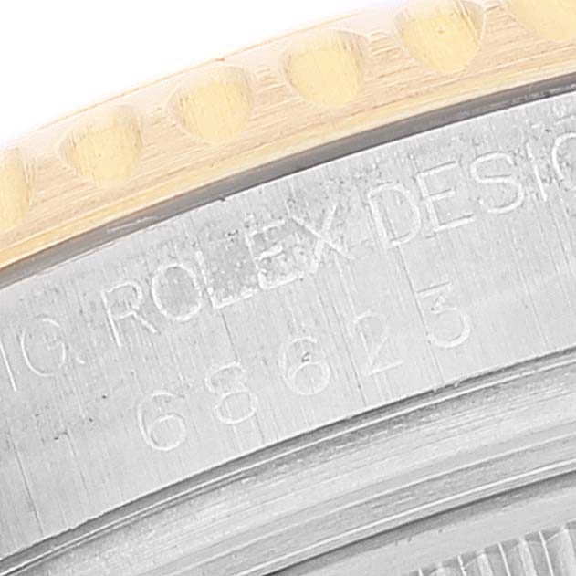 This close-up of the Rolex Yacht-Master 68623 Men's Steel and Gold (two tone) White Dial 68623 Men's Steel and Gold (two tone) White Dial watch shows part of the bezel and engraved lettering on the case.