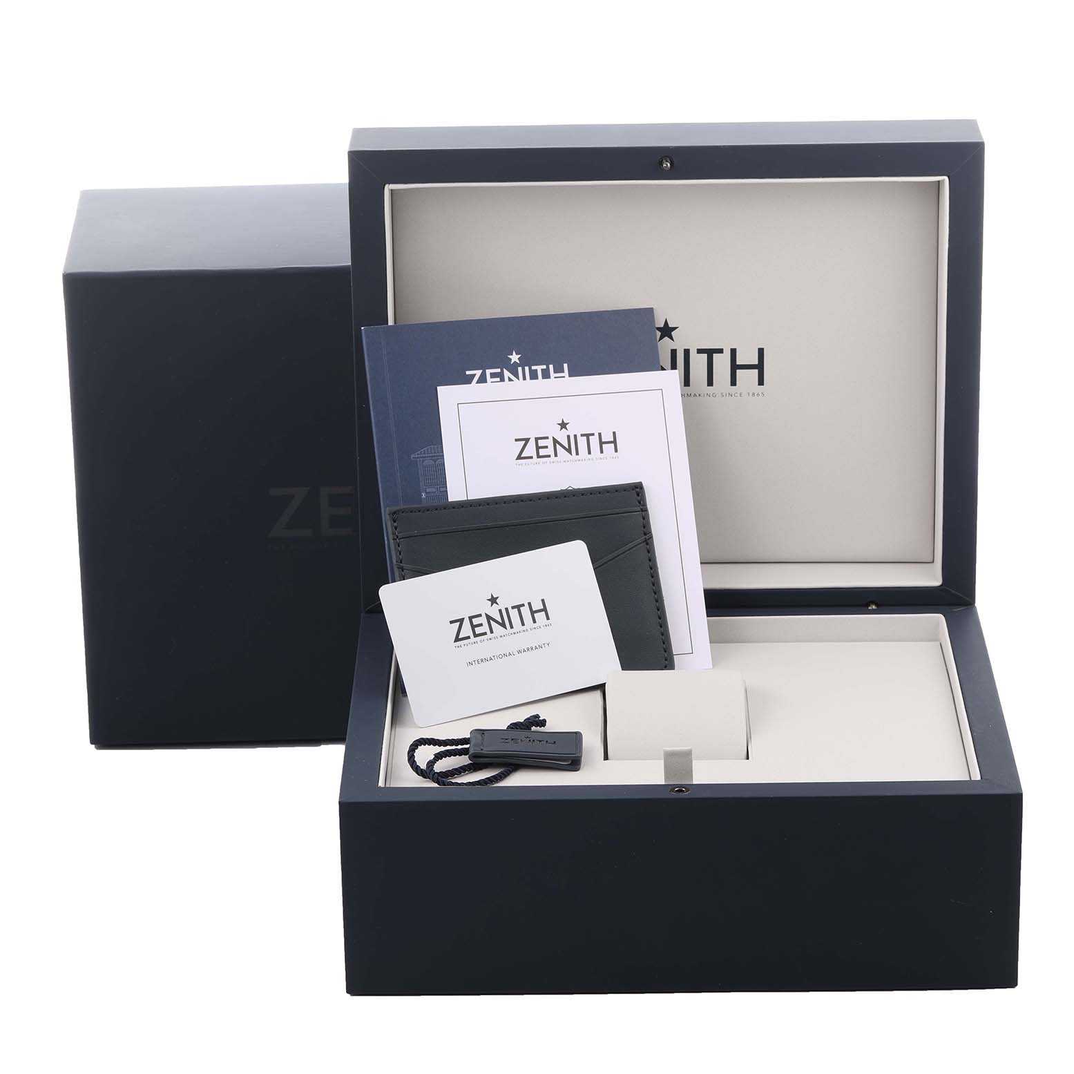 The image shows a Zenith Chronomaster 03.3200.3600/69C902 Men's Stainless Steel White Dial 03.3200.3600/69C902 Men's Stainless Steel White Dial watch box with warranty cards and a booklet, viewed from the front.
