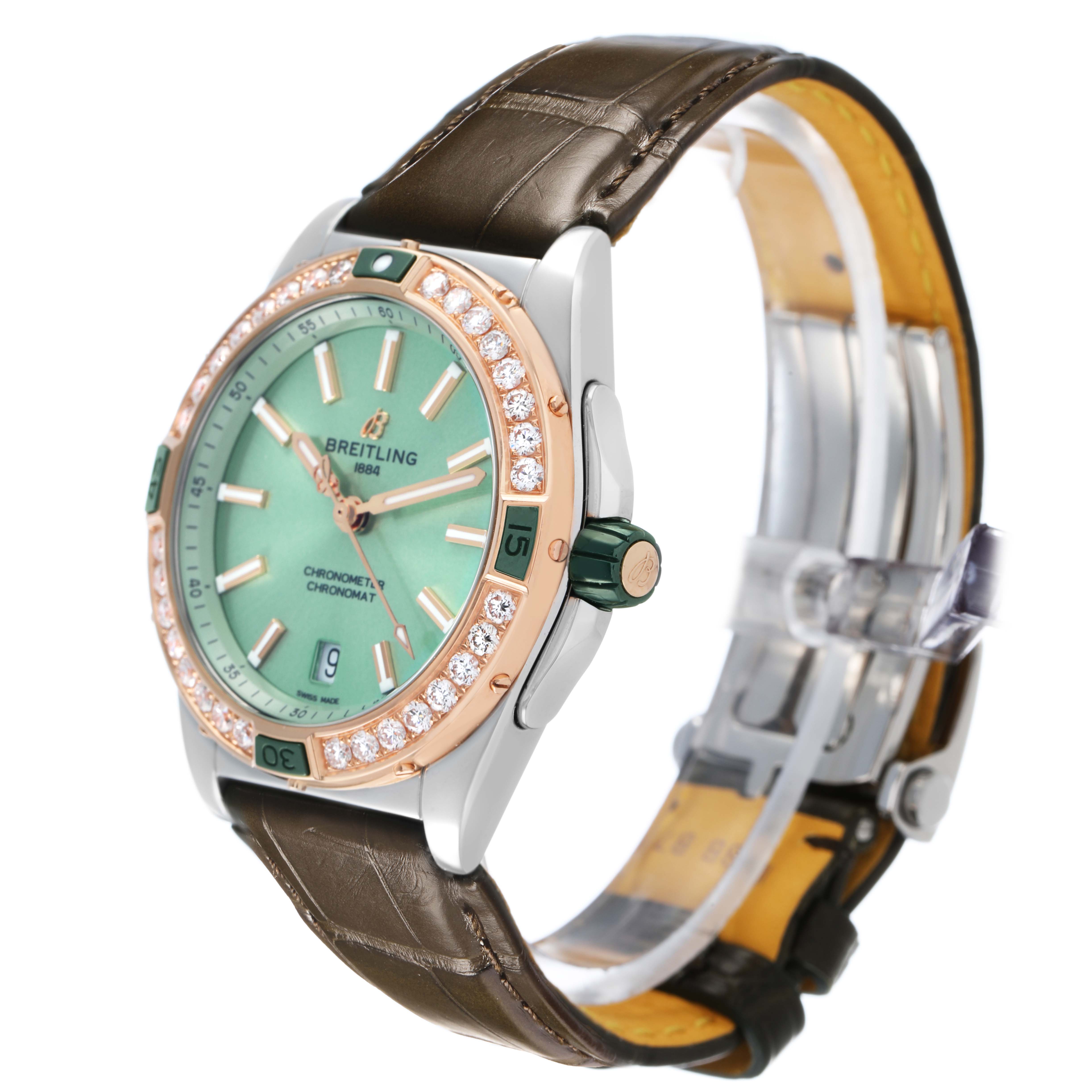 The Breitling U17356 Women's Stainless Steel Green Dial Super Chronomat U17356 is shown from an angled view showcasing its green dial, rose gold diamond bezel, and brown strap.