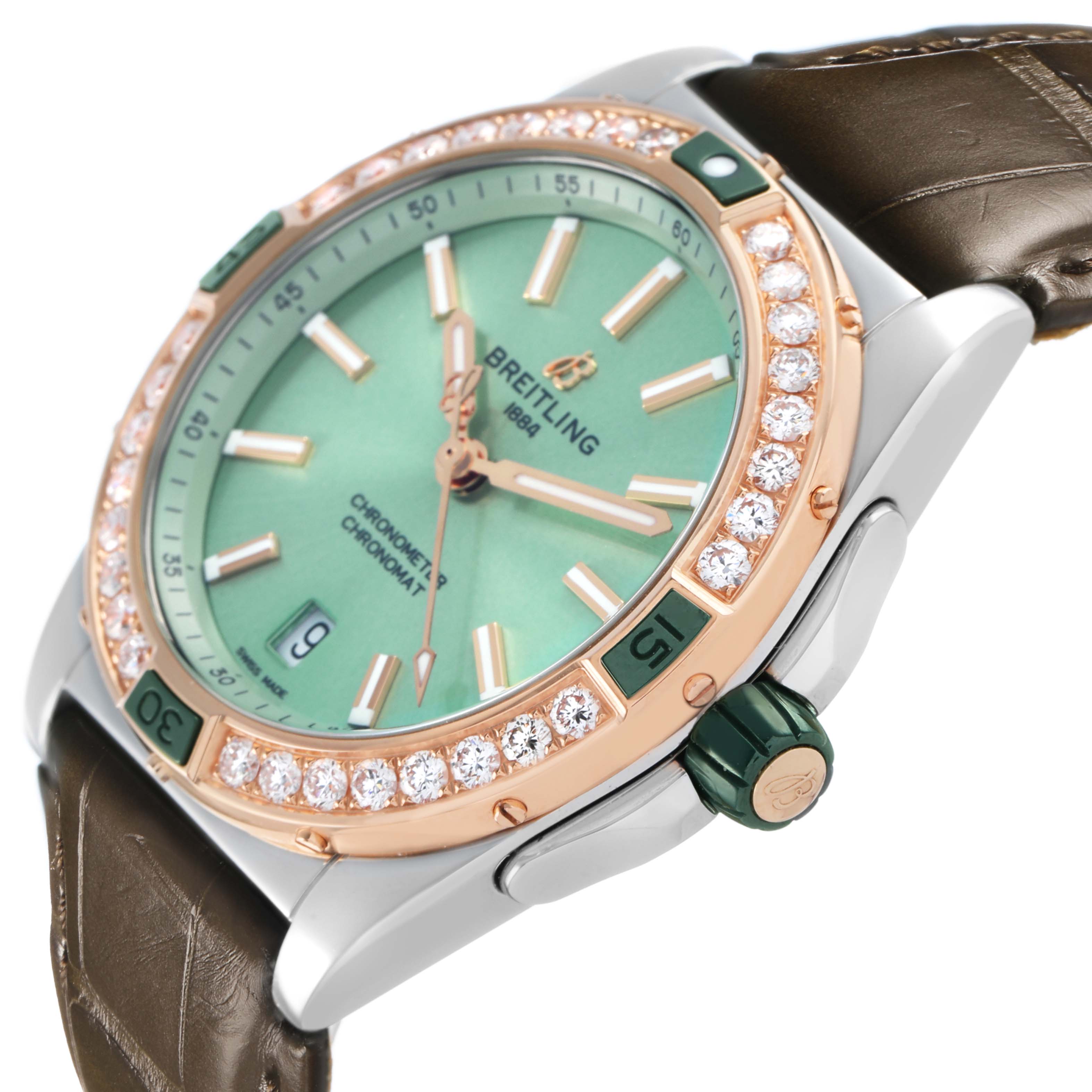 The Breitling U17356 Women's Stainless Steel Green Dial Super Chronomat U17356 is shown at an angled side view, highlighting its diamond-studded bezel, green dial, and leather strap.